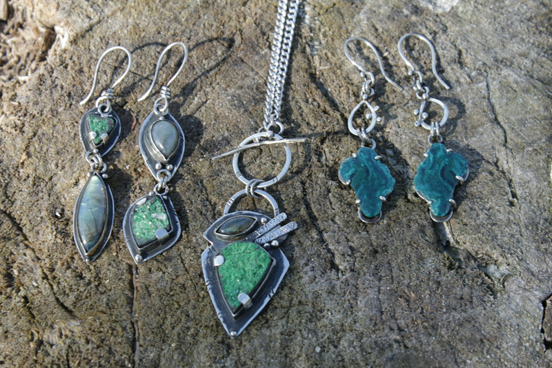 a group of jewelry sitting on top of a rock
