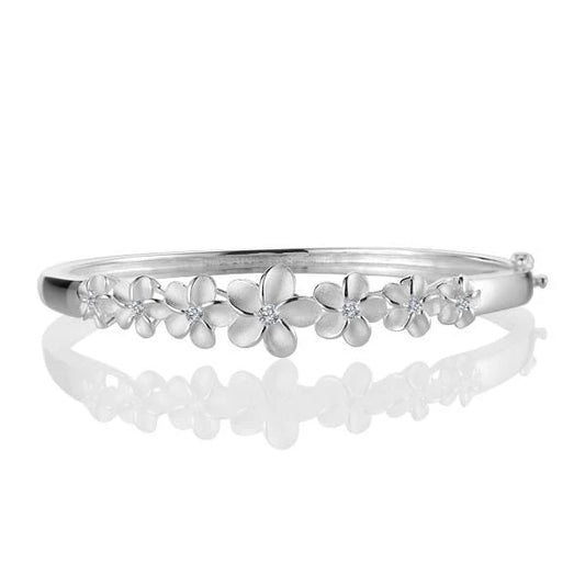 Sterling silver 7 Plumeria open bangle bracelet with cubic zirconia accents, crafted by Ashley's Gift Shop.