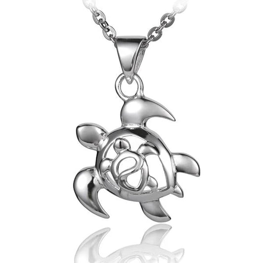 Left Honu pendant with tiny Honu inside, featuring a detailed sea turtle design in silver, crafted by Ashley's Gift Shop.