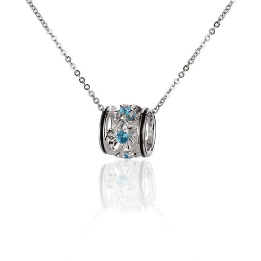 Blue CZ pendant with plumeria barrel shape, silver-toned jewelry piece displayed against a neutral background.