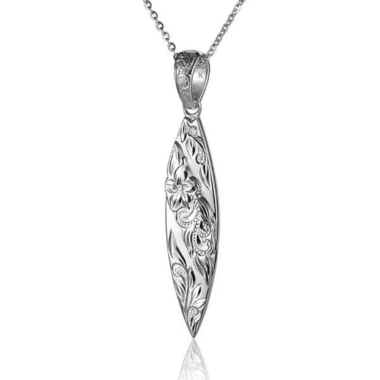 Raised scroll surfboard pendant from Ashley's Gift Shop featuring intricate scroll detailing on a sleek surfboard-shaped jewelry piece.