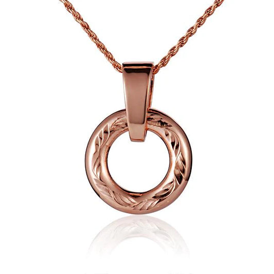 Round engraved pendant with intricate design, crafted by Ashley's Gift Shop, showcasing detailed engraving on polished silver surface.