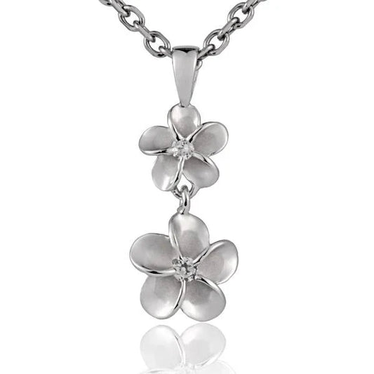 Sterling silver Plumeria CZ pendant with 8mm gemstone, showcasing intricate floral design on a polished surface.
