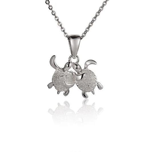 Twin turtle pendant necklace from Ashley's Gift Shop featuring two detailed turtle charms on a silver chain.